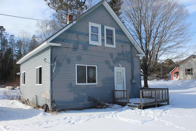 snow covered property with a wooden deck