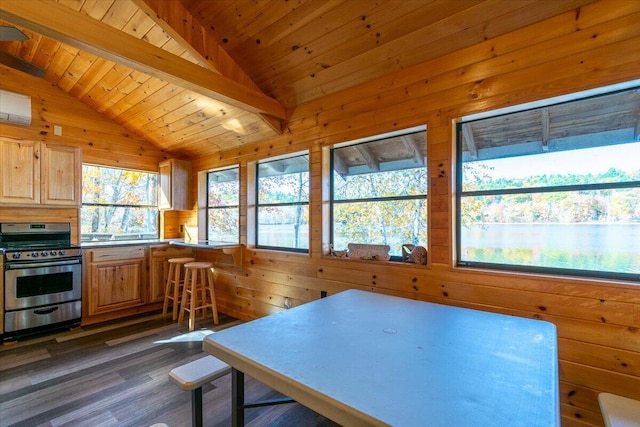 interior space featuring wood walls, stainless steel gas stove, vaulted ceiling with beams, light brown cabinets, and wooden ceiling