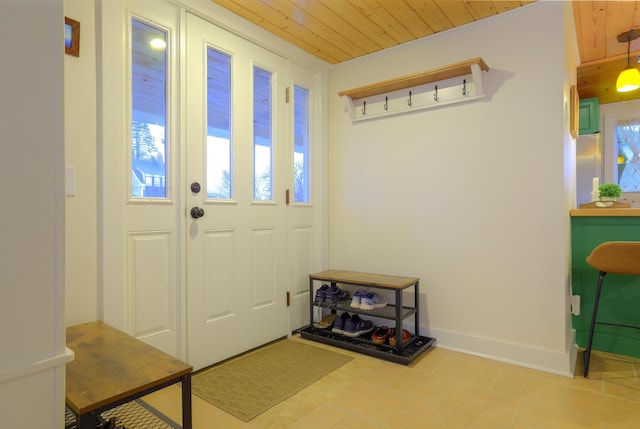 foyer featuring wood ceiling, crown molding, and light tile patterned flooring