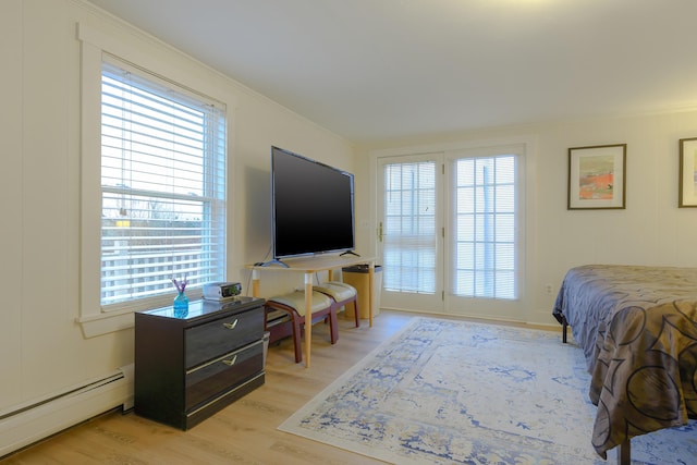 bedroom featuring a baseboard radiator, access to exterior, and light hardwood / wood-style flooring