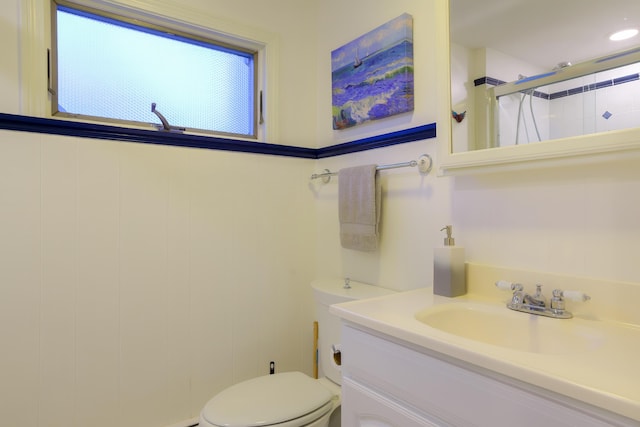 bathroom featuring vanity, toilet, and a shower with shower door