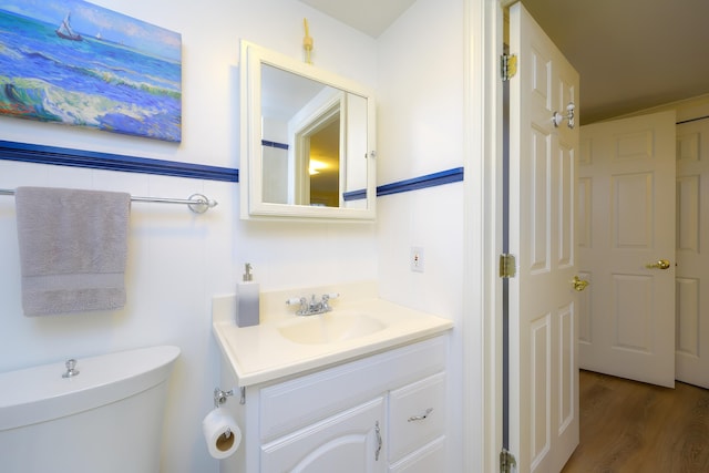 bathroom with vanity, wood-type flooring, and toilet