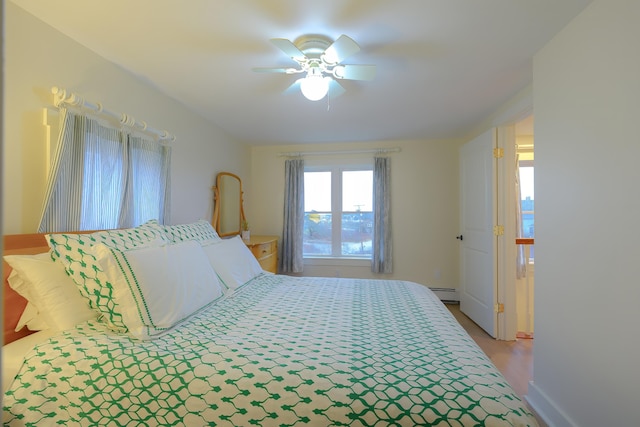 bedroom featuring a baseboard heating unit and ceiling fan