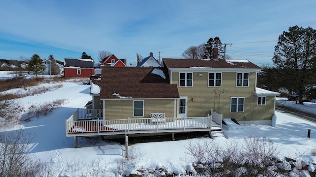 snow covered house featuring a wooden deck