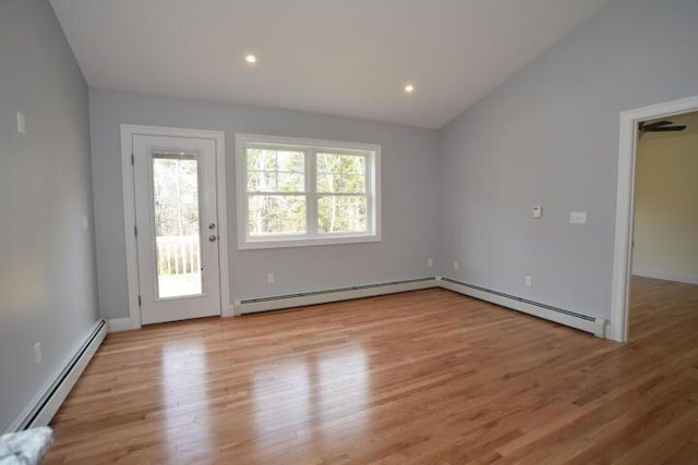 interior space with vaulted ceiling, light wood-type flooring, and baseboard heating