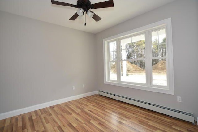 spare room with ceiling fan, baseboard heating, and light hardwood / wood-style floors