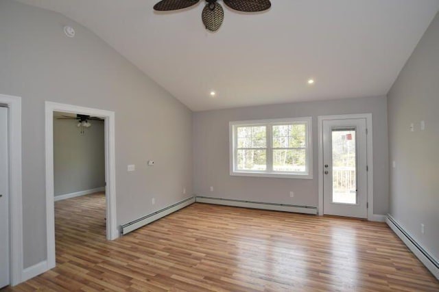 unfurnished room with lofted ceiling, a baseboard heating unit, and light hardwood / wood-style floors