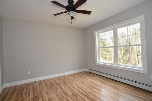 unfurnished room with ceiling fan, a baseboard radiator, and light hardwood / wood-style floors