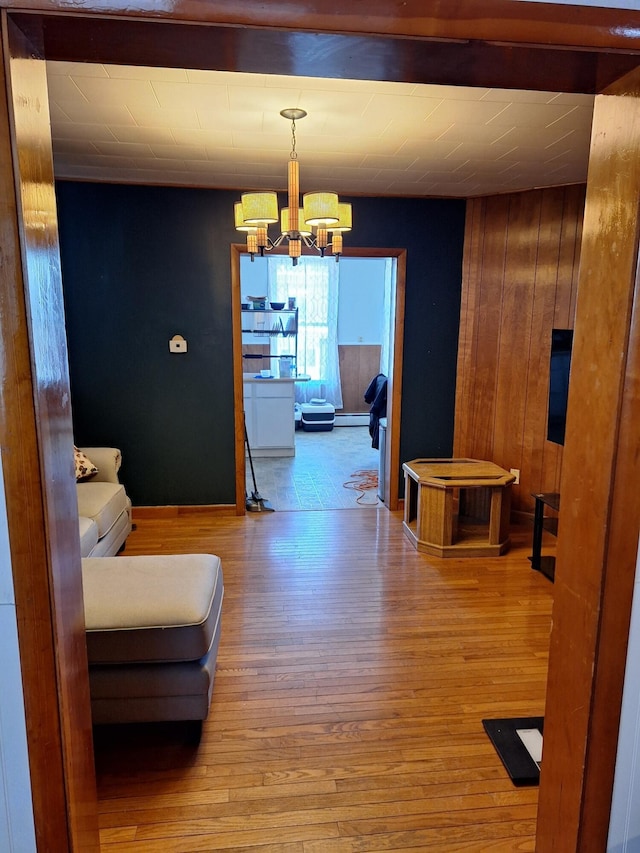 interior space with hardwood / wood-style floors, a baseboard radiator, and a chandelier