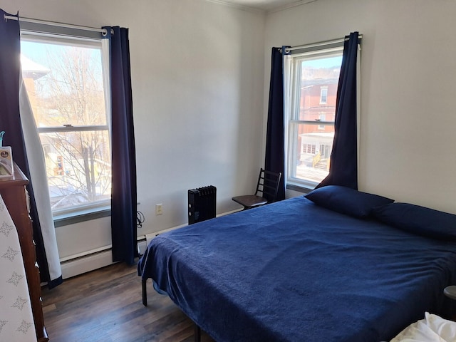 bedroom with dark hardwood / wood-style floors and baseboard heating