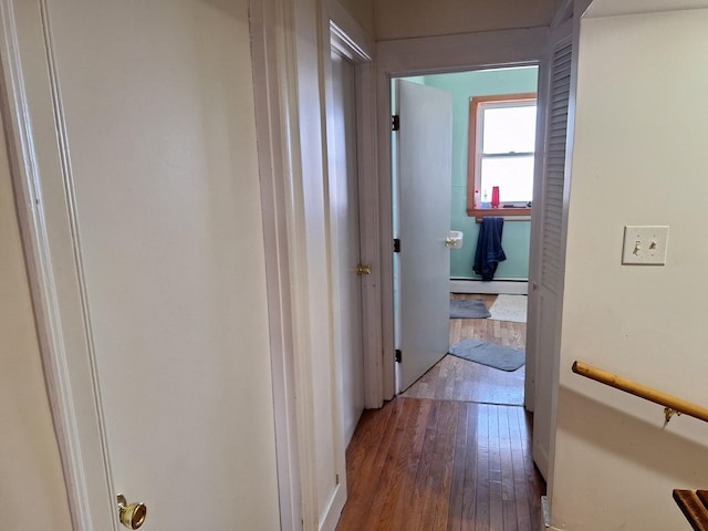 hall with baseboard heating and dark wood-type flooring