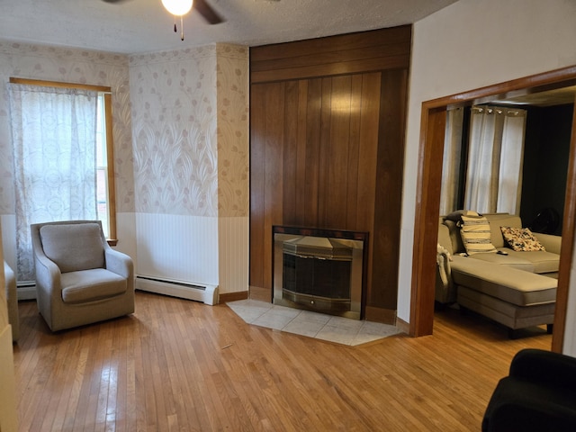 36 Erchles St, Rumford, ME 04276 - sitting room with a baseboard radiator, wallpapered walls, light wood-style flooring, and ceiling fan