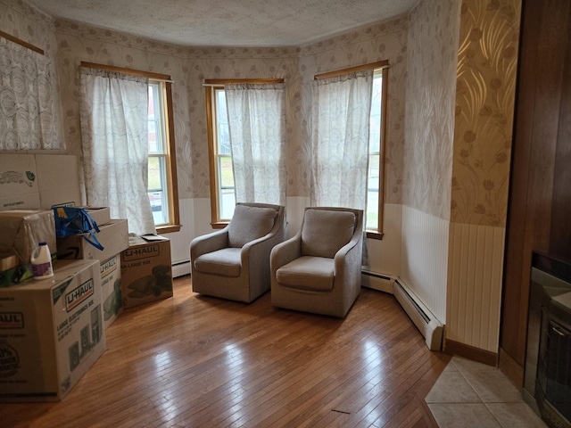 36 Erchles St, Rumford, ME 04276 - sitting room with wainscoting, a baseboard radiator, a healthy amount of sunlight, and wallpapered walls