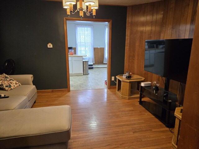 36 Erchles St, Rumford, ME 04276 - living area with wood-type flooring, an inviting chandelier, wood walls, and a baseboard radiator