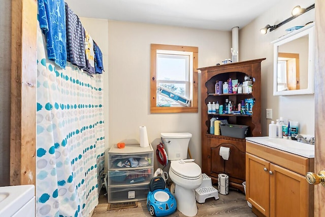 bathroom with hardwood / wood-style flooring, vanity, toilet, and a shower with curtain