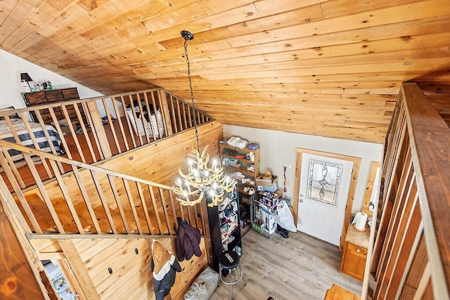 staircase with wood ceiling, vaulted ceiling, hardwood / wood-style floors, and a notable chandelier