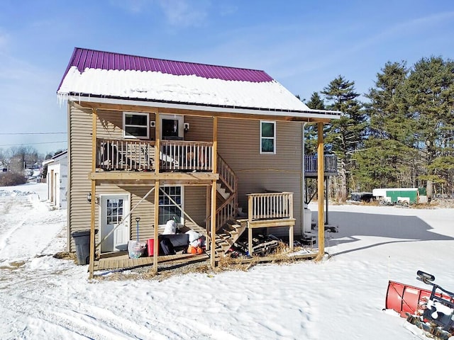 snow covered house featuring a deck