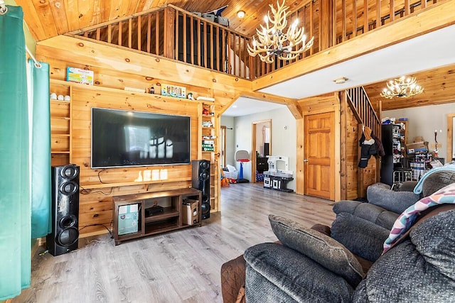 living room featuring a notable chandelier, wood ceiling, hardwood / wood-style floors, and wood walls