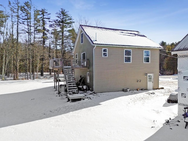 snow covered property with a wooden deck