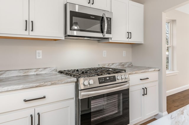 LOT9 Westhaven Ln, Wells, ME 04090 - kitchen with stainless steel appliances, white cabinets, baseboards, wood finished floors, and light stone counters