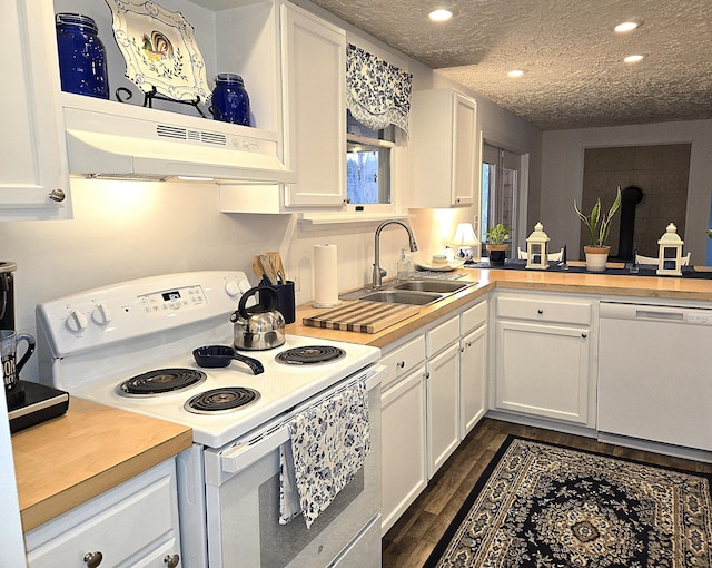 kitchen featuring sink, white cabinets, white appliances, dark wood-type flooring, and a textured ceiling