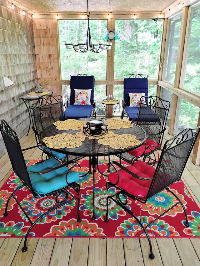 dining area with a chandelier and a wall of windows