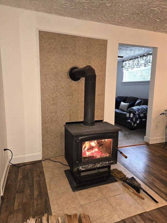 room details featuring hardwood / wood-style floors, a textured ceiling, and a wood stove