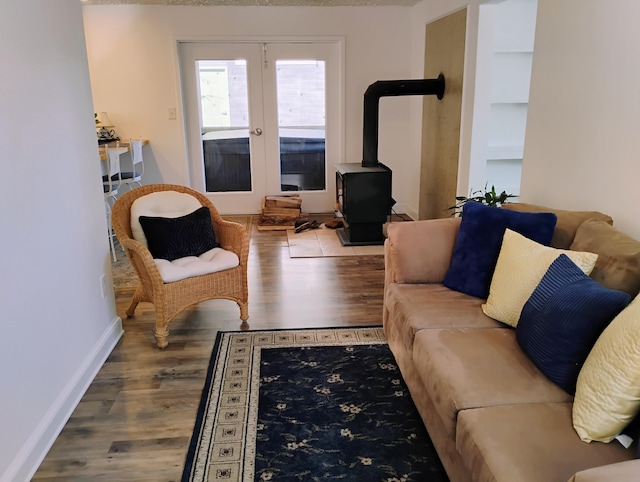 living room with wood-type flooring, french doors, and a wood stove