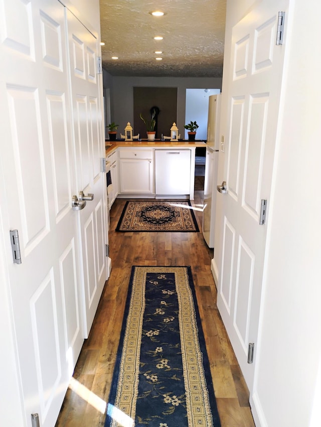 corridor featuring dark hardwood / wood-style floors and a textured ceiling