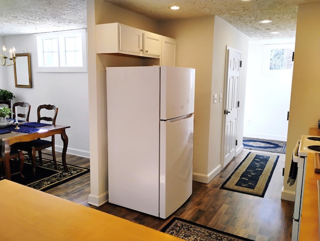 kitchen with white cabinetry, white appliances, a textured ceiling, and a healthy amount of sunlight