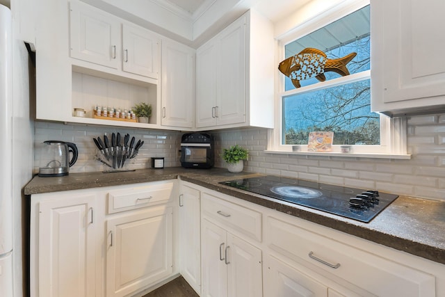 kitchen with black electric cooktop and white cabinetry