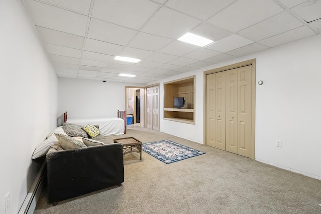 living room with a baseboard radiator, carpet floors, and a drop ceiling