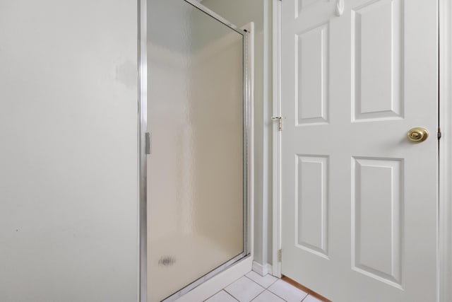 bathroom with tile patterned floors and a shower with shower door