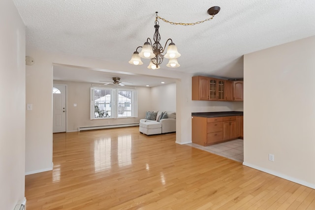 interior space featuring a baseboard heating unit, a textured ceiling, and light hardwood / wood-style flooring