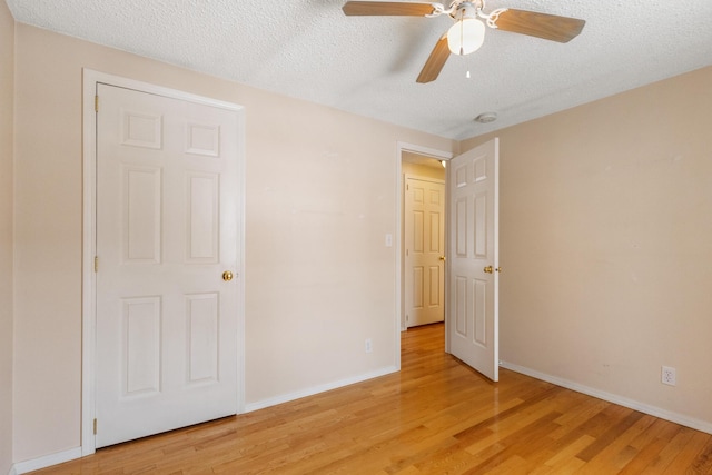 unfurnished bedroom with ceiling fan, a textured ceiling, and light wood-type flooring