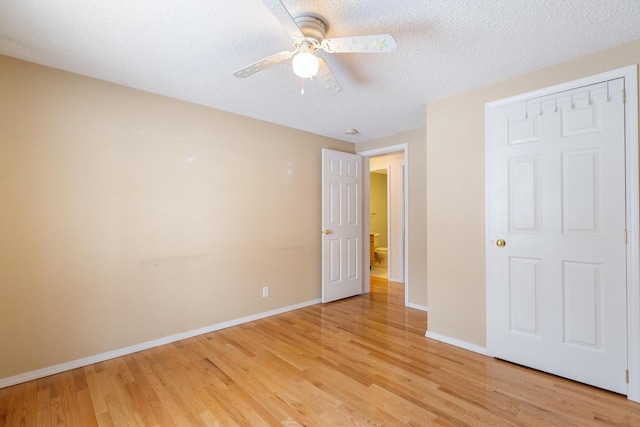 unfurnished bedroom featuring ceiling fan, a textured ceiling, and light hardwood / wood-style flooring