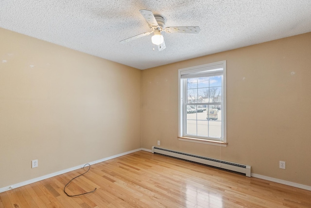 spare room with ceiling fan, a textured ceiling, baseboard heating, and light hardwood / wood-style floors