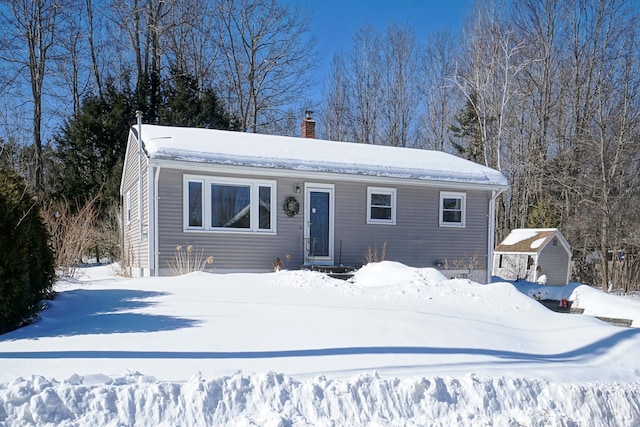 view of front of house with an outdoor structure and a chimney