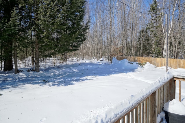 snowy yard featuring fence