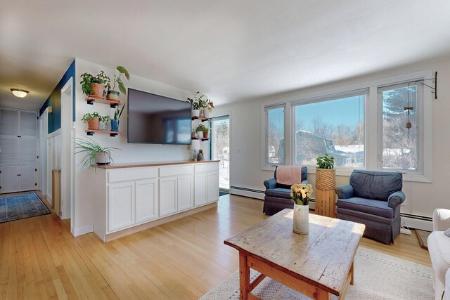 living area with baseboard heating and light wood-style floors