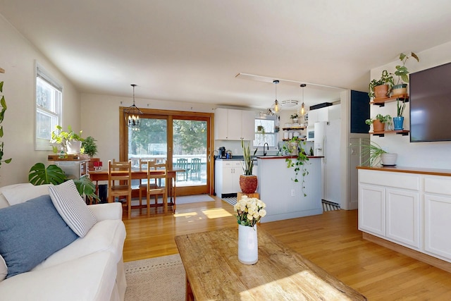 living room featuring a chandelier and light wood-type flooring