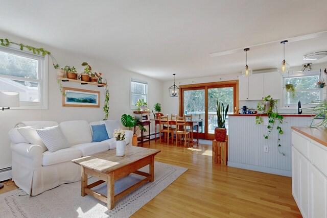 living area featuring baseboard heating and light wood finished floors