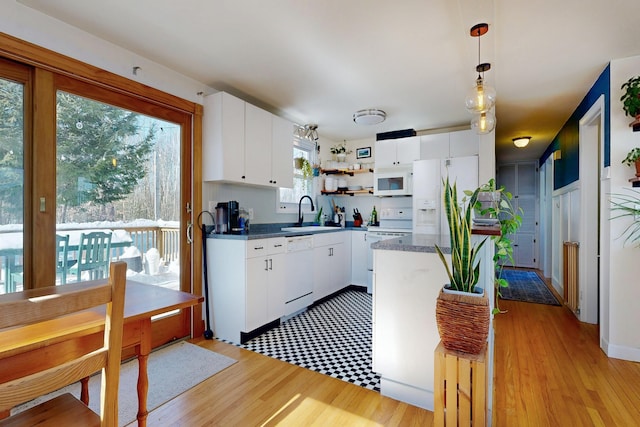 kitchen featuring open shelves, light wood-style floors, white cabinetry, a sink, and white appliances