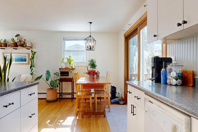 kitchen with pendant lighting, a notable chandelier, white cabinetry, light wood-type flooring, and dishwasher