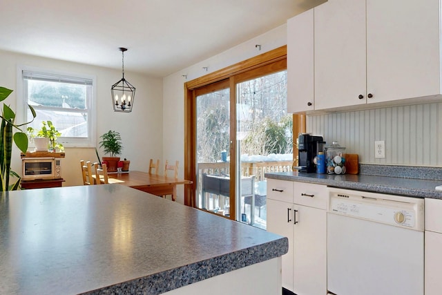 kitchen with a healthy amount of sunlight, pendant lighting, white cabinets, and dishwasher