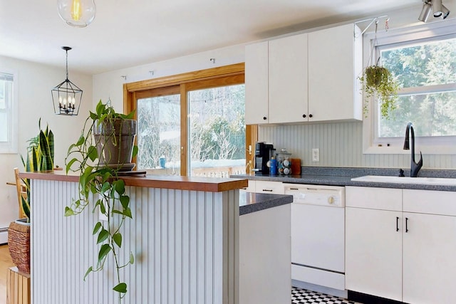 kitchen with a wealth of natural light, white cabinetry, white dishwasher, and a sink