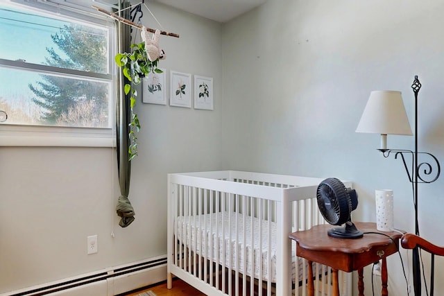 bedroom with a nursery area and baseboard heating