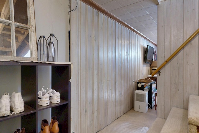 interior space with carpet and wooden walls