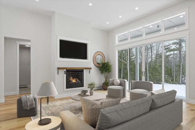 living room featuring a baseboard heating unit and light wood-type flooring