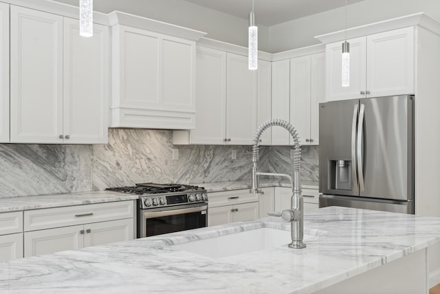 kitchen with white cabinetry, appliances with stainless steel finishes, tasteful backsplash, and pendant lighting